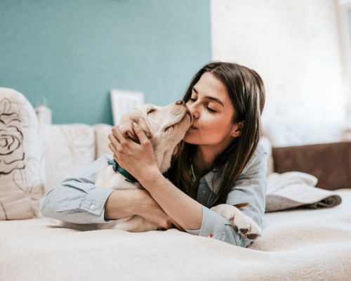 happy pet owner home page lady kissing her dog